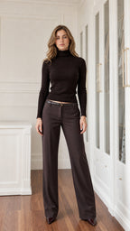 Full front view of model wearing black slim fit turtleneck sweater with dark trousers