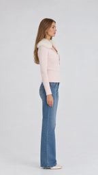 Side profile of model wearing pink faux fur zip-up knit sweater