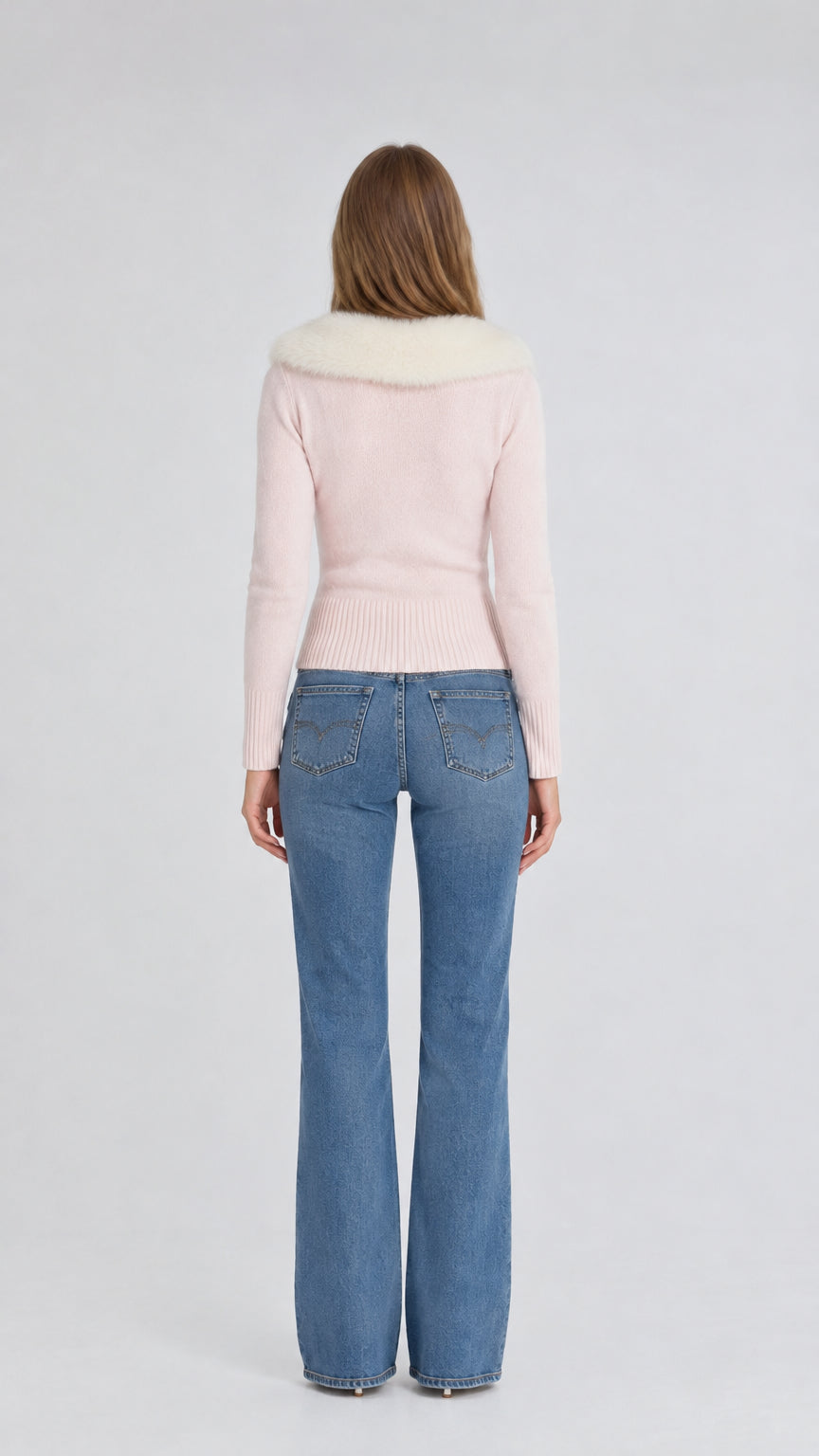 Back view of model wearing pink knit cardigan with plush fur collar