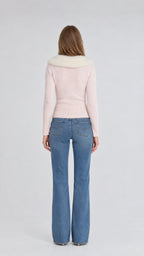 Back view of model wearing pink knit cardigan with plush fur collar
